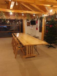 a large wooden table in a room with a christmas tree at VILA DAVELY in Câmpulung Moldovenesc