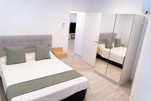 1 dormitorio con cama y espejo en Casa La Venta, en Campo de Criptana