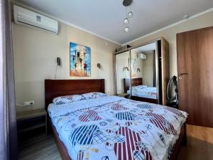 um quarto com uma cama grande e um espelho em Orbi Residence Batumi em Batumi