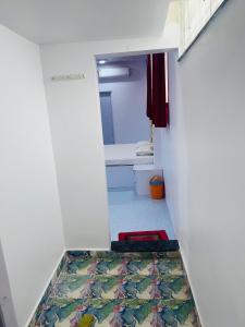 a hallway with a bathroom with a rug on the floor at Lotus in Nagpur