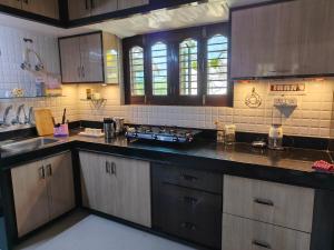 a large kitchen with wooden cabinets and a sink at Light House Homestay in Mount Ābu