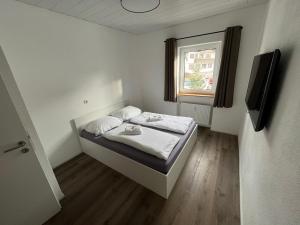 ein kleines Schlafzimmer mit einem Bett und einem Fenster in der Unterkunft Ferienwohnung im Stadtzentrum in Oberstaufen