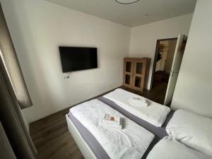 a hotel room with two beds and a flat screen tv at Ferienwohnung im Stadtzentrum in Oberstaufen