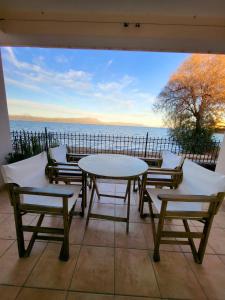 a table and chairs on a patio with a view of the water at Delion Guest Apartment in Dhílesi