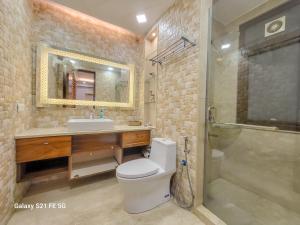 La salle de bains est pourvue de toilettes, d'un lavabo et d'une douche. dans l'établissement Pratishtha 4BHK, DLF Phase 1, Gurgaon, à Gurgaon