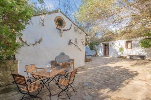 een tafel en stoelen voor een gebouw bij Apartamento Cortijo Rural Las Aves in Jimena de la Frontera