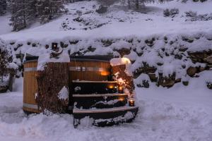 Ski in & out Chalet Marmo in Zermatt في زيرمات: حوض استحمام ساخن مع النار في الثلج