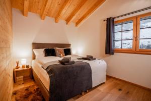 a bedroom with a bed and a large window at Ski in & out Chalet Marmo in Zermatt in Zermatt