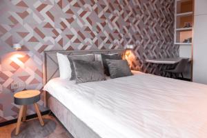a bedroom with a bed with a geometric wall at Bright Kaunas apartment with Castle view in Kaunas