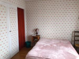 ein Schlafzimmer mit einem Bett in einem Zimmer mit Tapete in der Unterkunft Chambre 1 double dans un appartement in Bourg-en-Bresse
