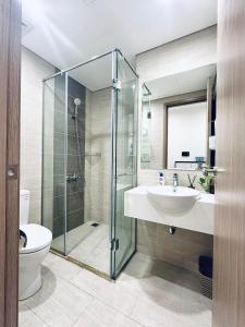 La salle de bains est pourvue d'une douche en verre et d'un lavabo. dans l'établissement Căn hộ chung cư cao cấp Ocean Park 2BR 2BA, à Hanoï