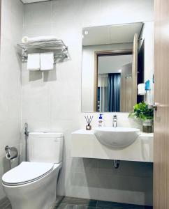 La salle de bains est pourvue de toilettes, d'un lavabo et d'un miroir. dans l'établissement Căn hộ chung cư cao cấp Ocean Park 2BR 2BA, à Hanoï