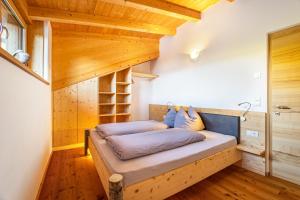 ルゾーンにあるKreuzplonhof Apt Karspitzの木製の天井の客室のベッド1台分です。
