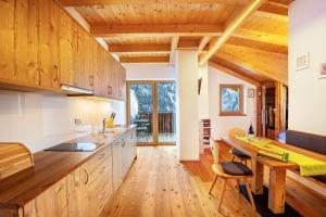uma cozinha com armários de madeira e uma mesa de madeira em Kreuzplonhof Apt Karspitz em Luson
