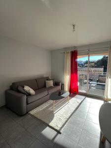 - un salon avec un canapé et une table dans l'établissement Appartement T2 avec terrasse sud, à Rochefort-du-Gard