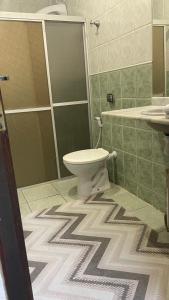 a bathroom with a toilet and a sink at ACM Flat in Natal
