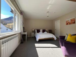 a bedroom with a bed and a large window at Strathassynt Guest House in Glencoe