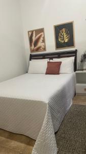 a bedroom with a large bed with white sheets at ACM Flat in Natal