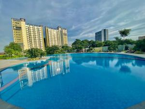 a large blue swimming pool with buildings in the background at Studio With balcony in Carreta
