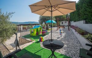 Villa Marko في بوجي: ملعب صغير مع طاولة ومظلة