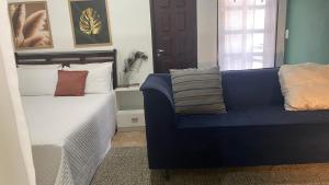 a blue couch in a room with a bed at ACM Flat in Natal