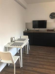una mesa blanca y sillas en una habitación con TV en Self-Check Apartment Lilia 3 next ot 24 hours food and drink shop and free parking area en Sofía