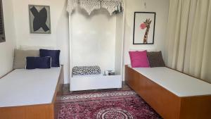 two beds sitting in a room with a rug at ACM Flat in Natal