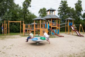 two boys playing on a playground in the sand at Chalet Havenzicht Eernewoude in Earnewâld