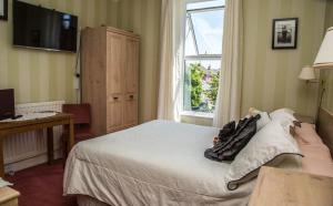 een hotelkamer met een bed en een raam bij Cambridge Villa in Warwick
