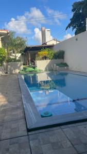 a swimming pool in front of a house at ACM Flat in Natal