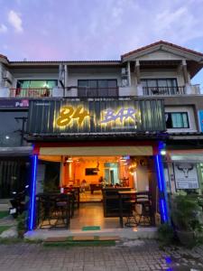 un restaurante con mesas y sillas frente a un edificio en 84 Bar & Guest House Room 3, en Ban Huai Luk (1)
