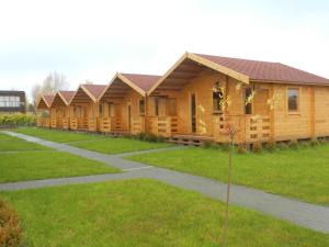 a row of wooden lodges in a park at Domki u Szostaków in Dąbki