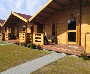 a log cabin with a porch and a deck at Domki u Szostaków in Dąbki