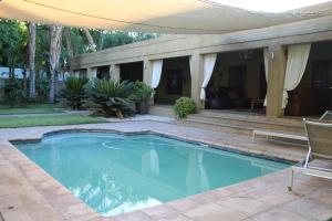 a swimming pool in a yard with a patio at Peaceful Garden Cottage in Kakamas