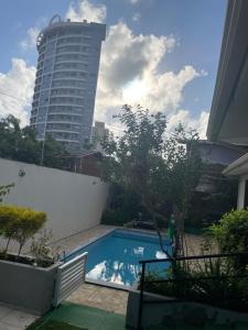 a swimming pool with a tall building in the background at ACM Flat in Natal