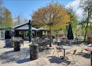 een restaurant met tafels, stoelen en parasols bij Chalet Havenzicht Eernewoude in Earnewâld