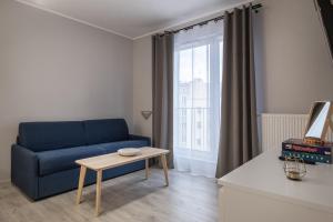 a living room with a blue couch and a table at 02 Gdynia Premium - Apartament Mieszkanie dla 2os in Gdynia
