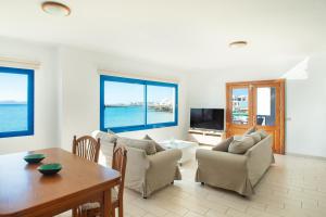 a living room with a table and chairs and the ocean at Blancazul Mingo Bajo in Playa Blanca