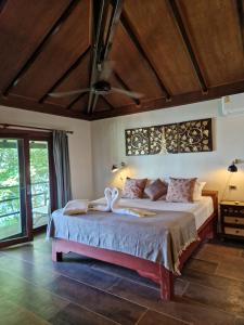 Un dormitorio con una cama con dos cisnes. en Jasmin Garden Koh Kood, en Ko Kood