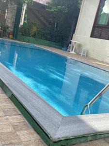 a swimming pool with blue water in a building at ACM Flat in Natal