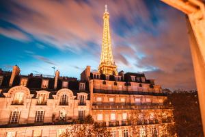 een gebouw met de eiffeltoren op de achtergrond bij Luxurious 2 Bedroom Tour Eiffel Bourdonnais Free Netflix in Parijs