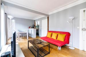 een woonkamer met een rode bank en gele kussens bij Luxurious 2 Bedroom Tour Eiffel Bourdonnais Free Netflix in Parijs
