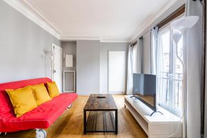een woonkamer met een rode bank en een tafel bij Luxurious 2 Bedroom Tour Eiffel Bourdonnais Free Netflix in Parijs