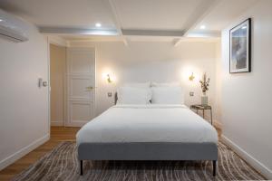 um quarto com uma grande cama branca com almofadas brancas em Opera Residence em Paris