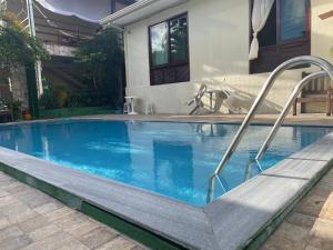a swimming pool with a stairway leading to a house at ACM Flat in Natal