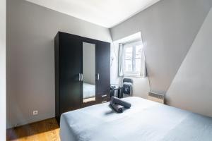 een slaapkamer met een bed en een zwarte kast bij Luxurious 2 Bedroom Tour Eiffel Bourdonnais Free Netflix in Parijs