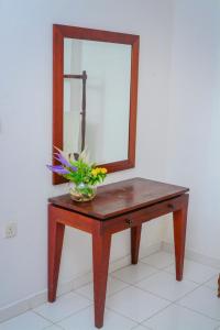 - une table avec un miroir et un bol de fleurs dans l'établissement SAKURAHANA VILLA AND AYURVEDA, à Aluthgama