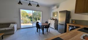 eine Küche und ein Wohnzimmer mit einem Tisch und Stühlen in der Unterkunft Jolie maison neuve entre mer et colline en Provence in Ollioules