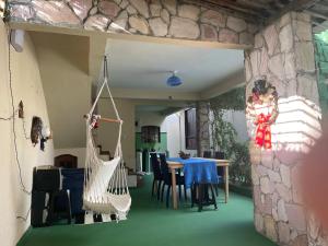 a room with a table and chairs and a stone wall at ACM Flat in Natal