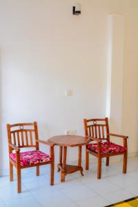 two chairs and a wooden table and a table and chairs at SAKURAHANA VILLA AND AYURVEDA in Aluthgama
